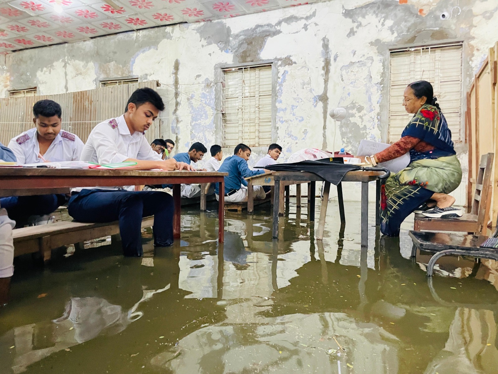 কুমিল্লায় জলাবদ্ধতায় বেঞ্চে পা তুলে পরীক্ষা দিচ্ছেন এসএসসি পরীক্ষার্থীরা